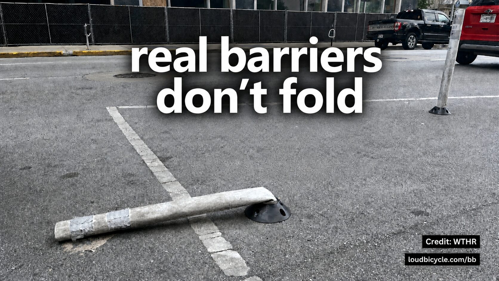 A flexible plastic bollard snapped off and lying flat in the road